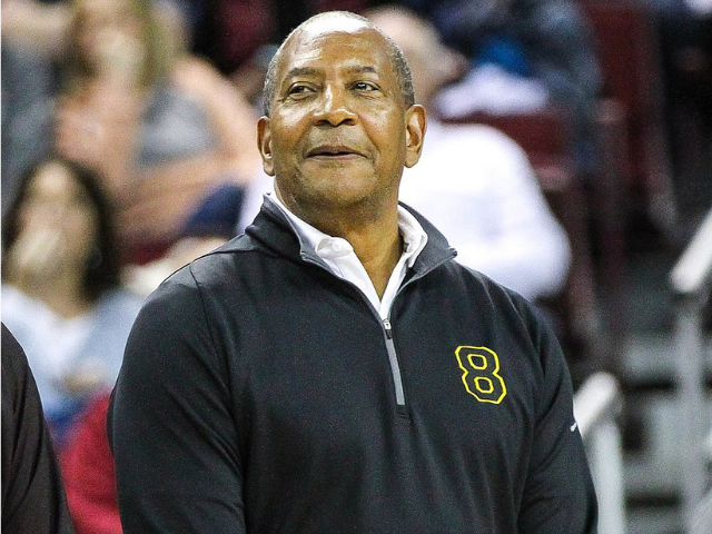 Alex English wearing a dark grey shirt with a yellow eight on the right side of the shirt.