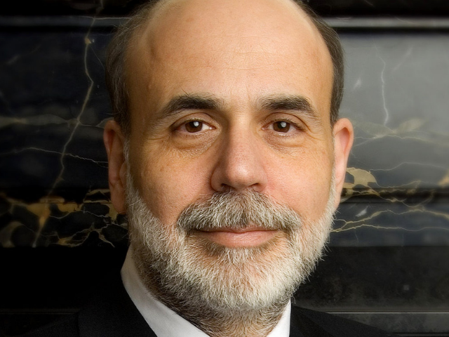 Ben Bernanke in a black suite with a blue, white, and black striped tie. 