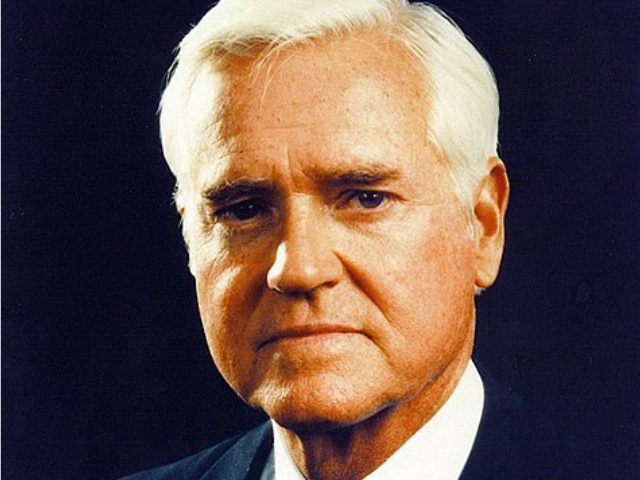 Fritz Hollings in a black suit, white undershirt, and black tie. 