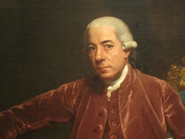 Henry Laurens wearing a powdered wig ad a burgundy coat with a white ruffled tie. 