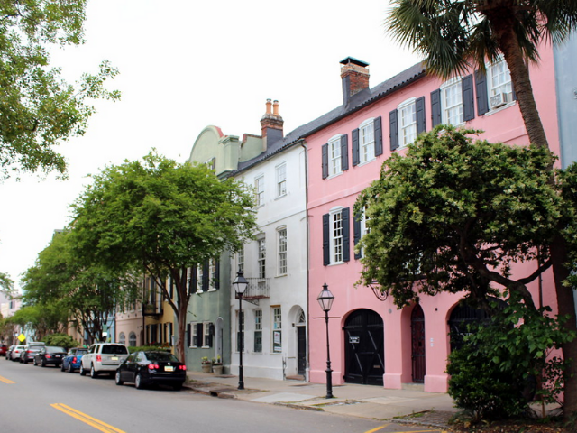 Pink, white, green, yellow and other colorful buildings lined the tree-lined street. 