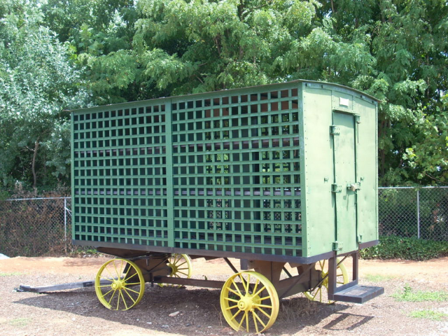 A small green wagon with yellow wheels. 