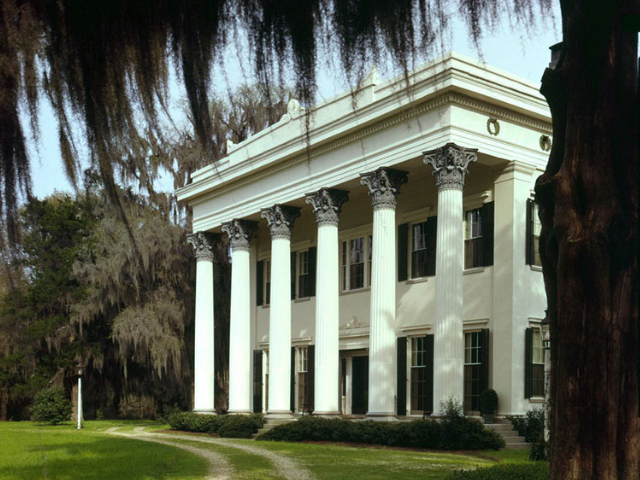 A large white square building with huge white columns in the front. 