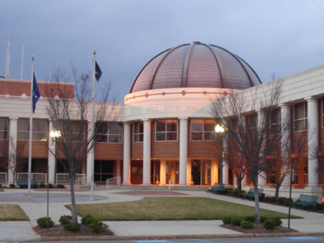 A large building with a large dome shaped roof and multiple white columns. 