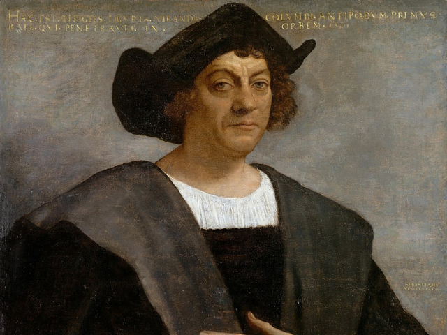 A stern looking man with curly brown hair wearing a brownish black hat and robe with a white scoop collar. 