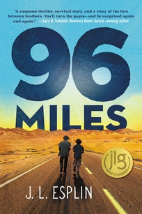 Two boys walk down a desert highway. 