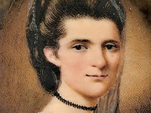Elizabeth Timothy wearing a lacy veil, a black choker, and mauve colored dress.