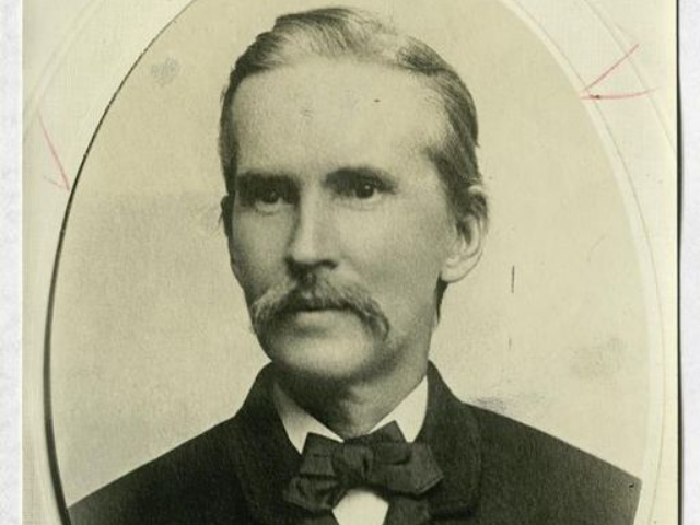 A older man wearing a dark bow tie. 