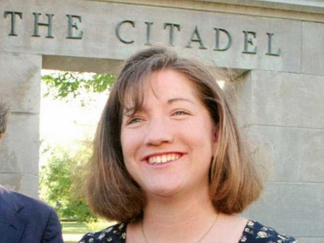 Color photograph of Shannon Faulkner, smiling, standing in front of the Citadel