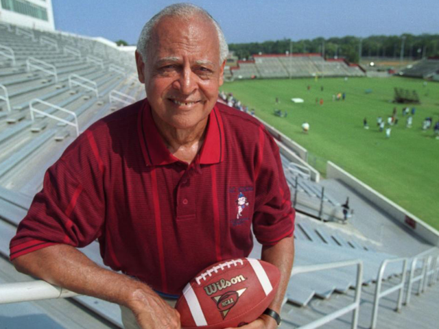 Willie Jeffries holding football with stadium in background