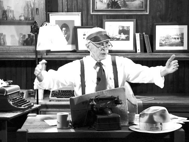 Robert Quillen sitting at his desk behind a typewriter