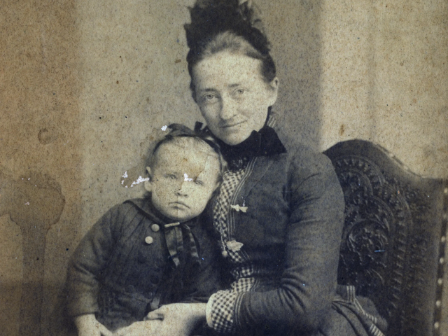 Black and white photograph of Abbie Christensen holding a child in her lap